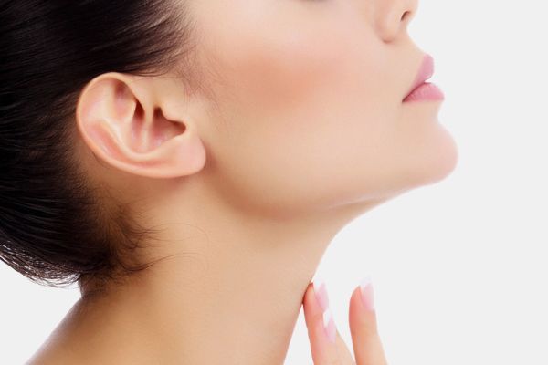 A close up of a woman 's neck and ear on a white background.