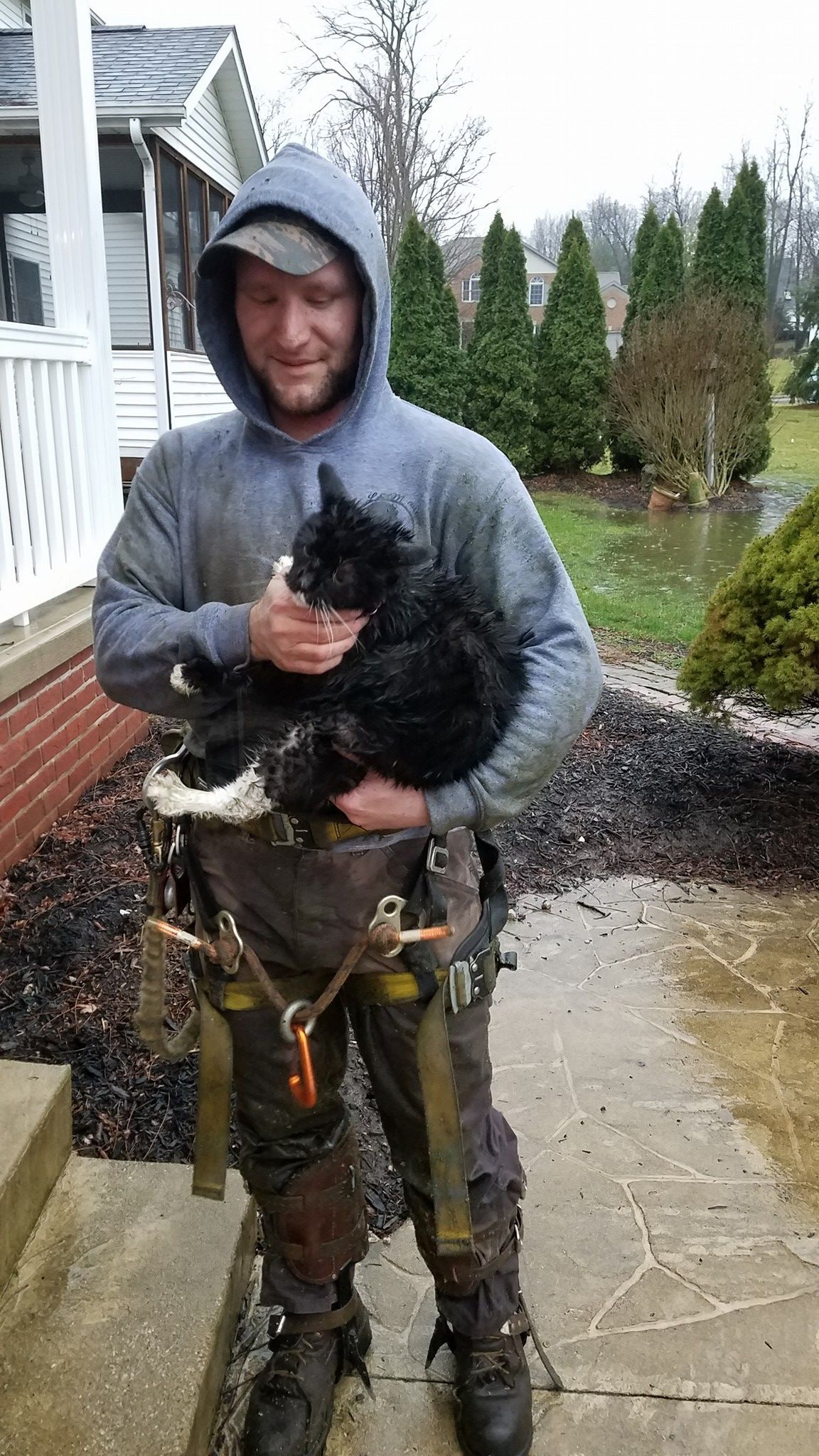 a man is holding a black cat in his arms