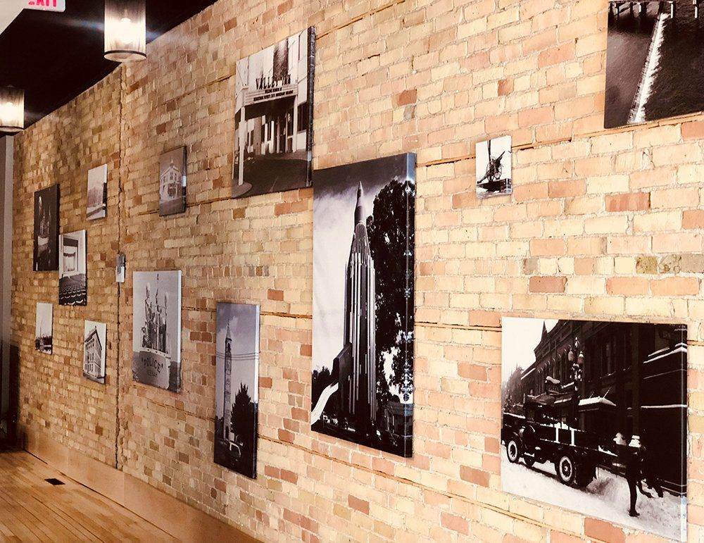 A brick wall with a lot of pictures on it