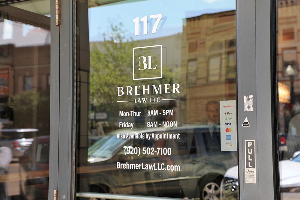 A glass door with a sign on it that says brehmer law llc.