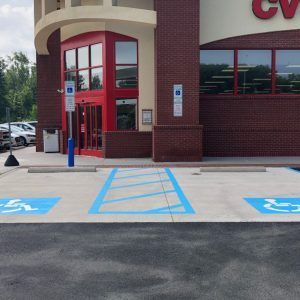 Accessible parking spaces and ramp outside a CVS store entrance with red doors.