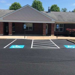 Accessible parking spaces in front of a brick building entrance