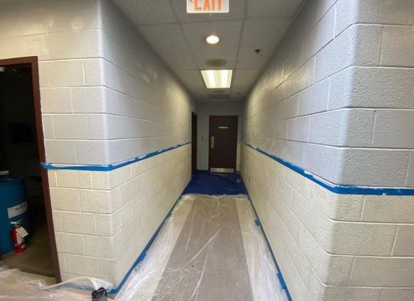 a long hallway with a red exit sign on the ceiling