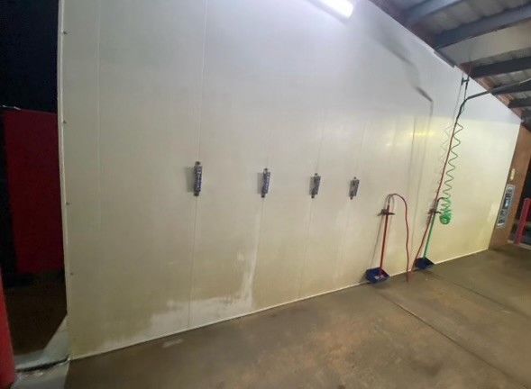 a large white wall with a bunch of hooks on it in a room .
