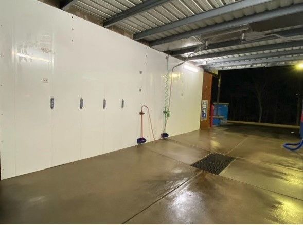 a car wash with a white wall and a concrete floor .