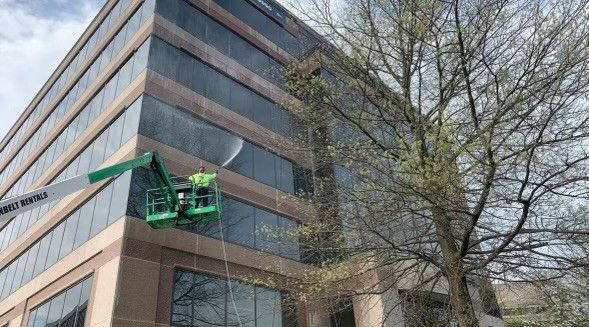a man is cleaning the windows of a large building .