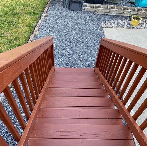 a set of wooden stairs leading up to a gravel path