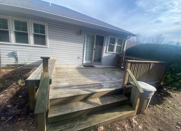 a house with a wooden deck and stairs in front of it .