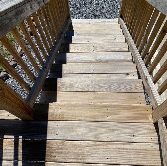 a set of wooden stairs with a wooden railing