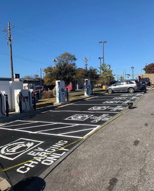 a parking lot with a lot of charging stations and cars parked in it .