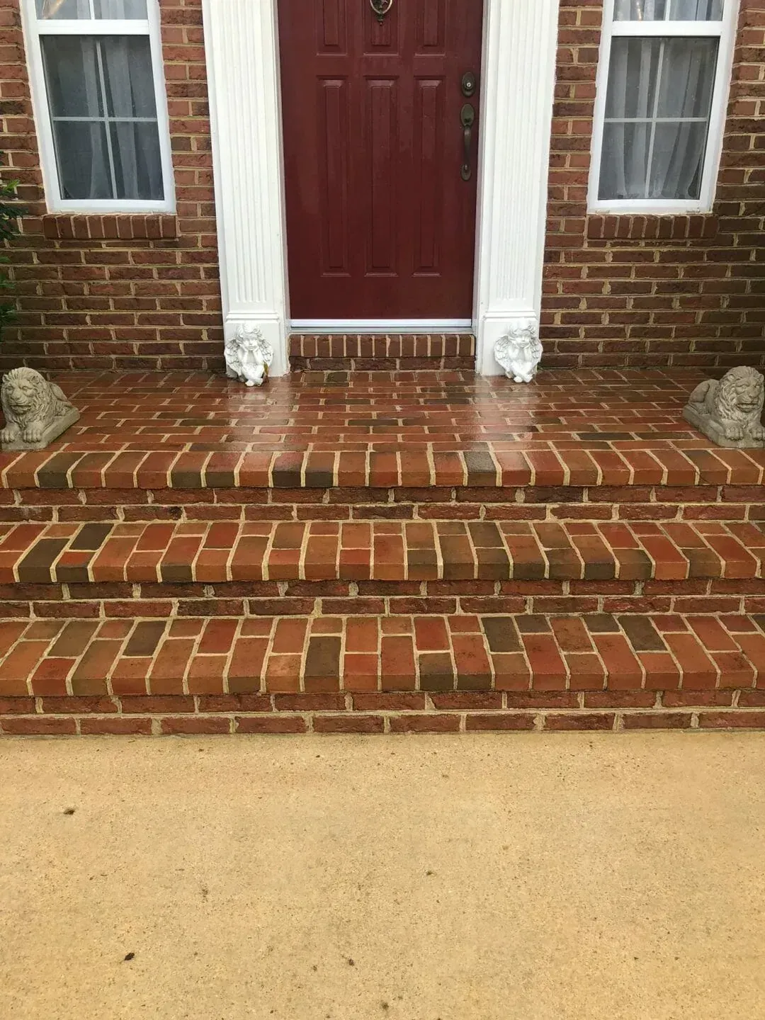 a brick porch with a red door and steps