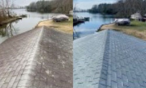 Before-and-after view of a roof. The left side is dirty, while the right side has been cleaned to reveal its original color. A waterway and trees are in the background.