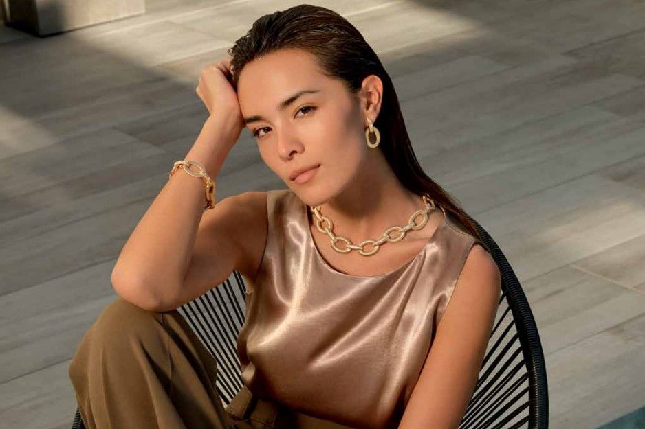 A woman wearing a Roberto Coin necklace and earrings