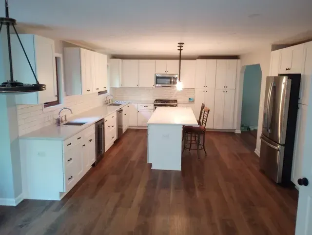A kitchen with white cabinets and stainless steel appliances