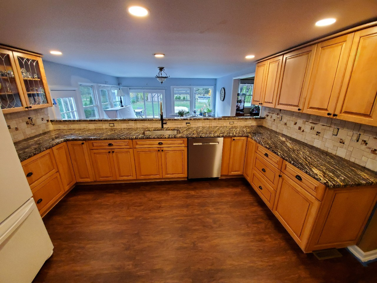 A kitchen with wooden cabinets and granite counter tops.