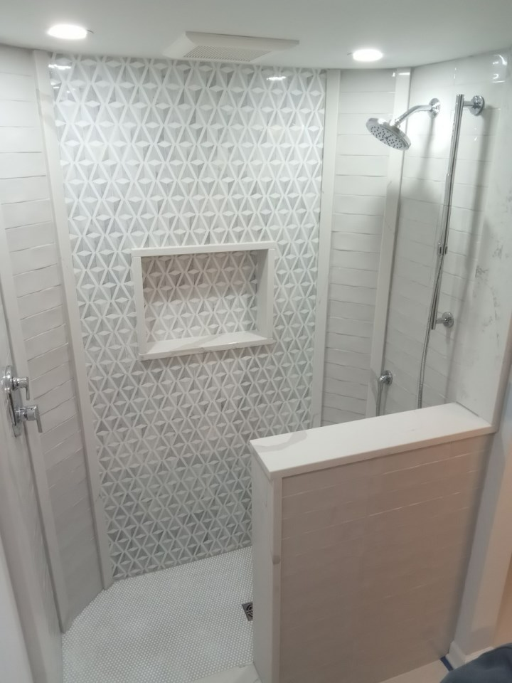A bathroom with a shower and a shelf in it