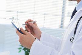 Doctor in white coat using a tablet