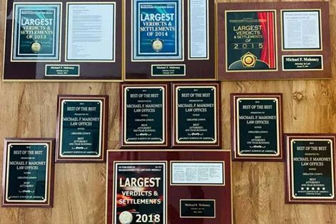 Awards on a wooden wall, including
