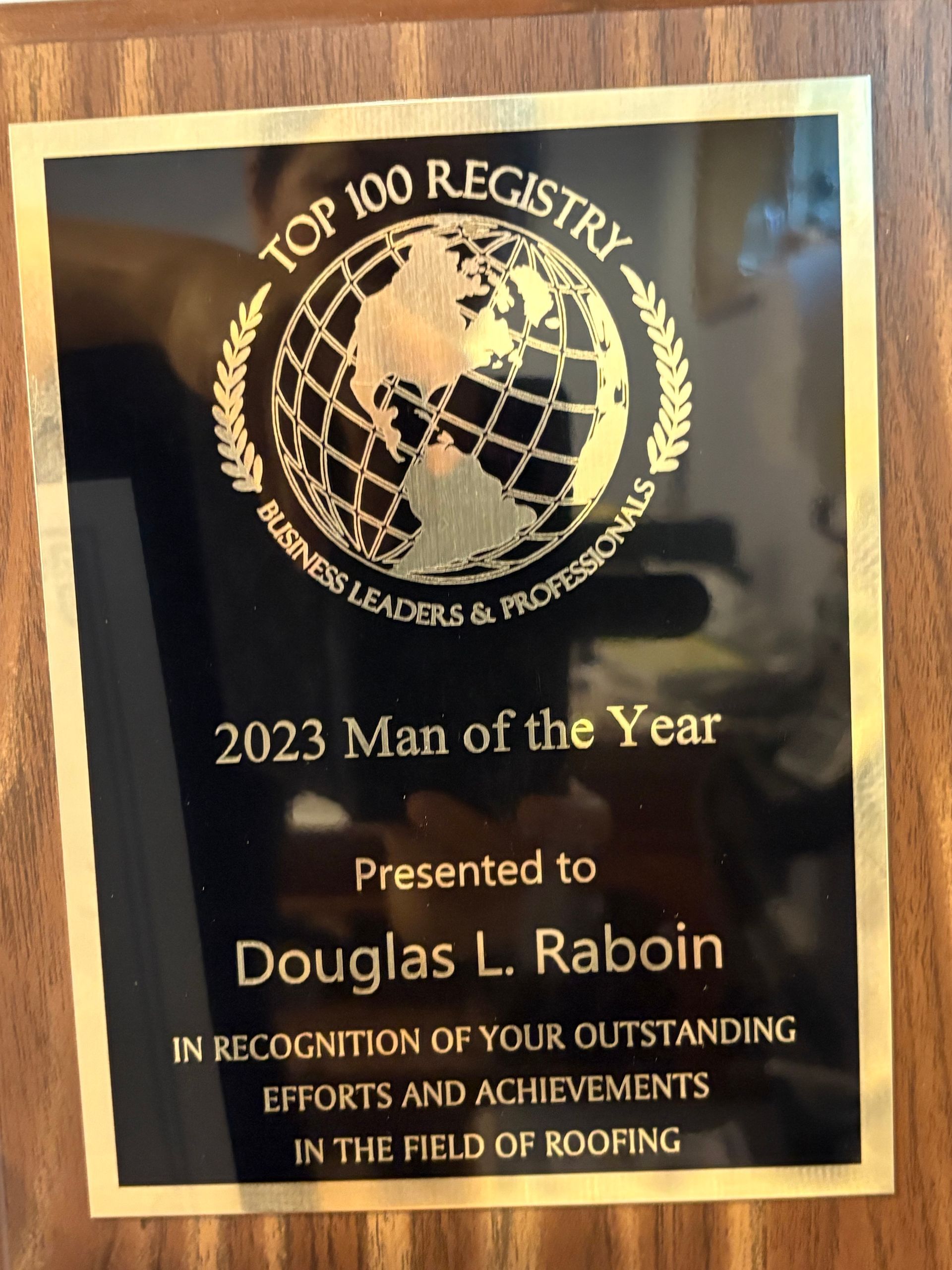 Plaque reading “2023 Man of the Year” presented to Douglas L. Rabin by Top 100 Registry in roofing recognition