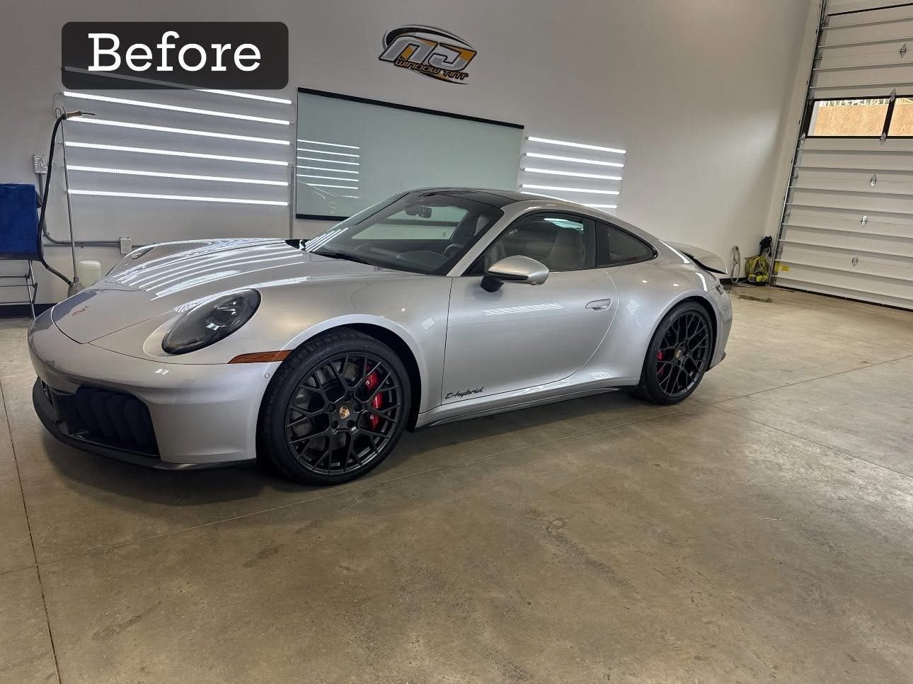Silver Porsche sports car inside a garage; Before label at top.