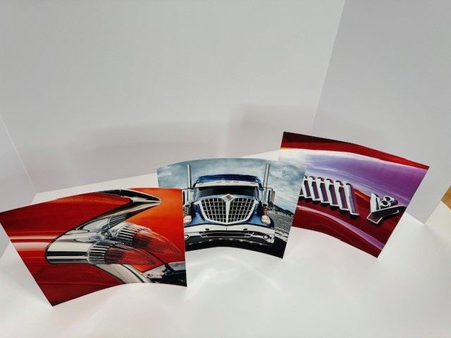 Three curved panels with images: red car detail, truck, and red car detail with 