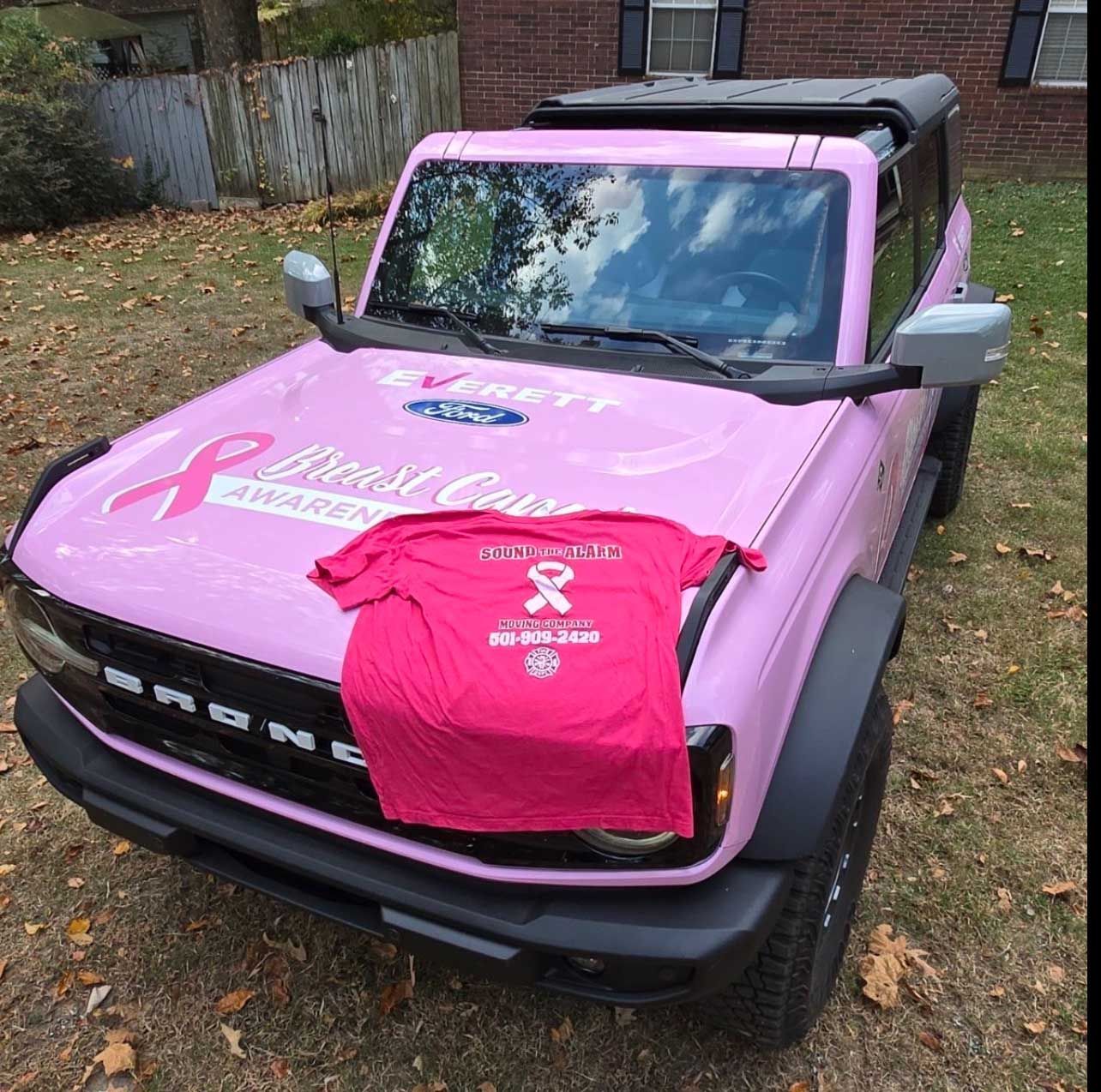 Pink Ford Bronco with breast cancer awareness ribbon and shirt.