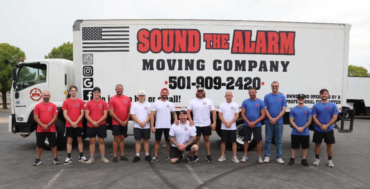 Sound the Alarm Moving Company team posing in front of their truck.