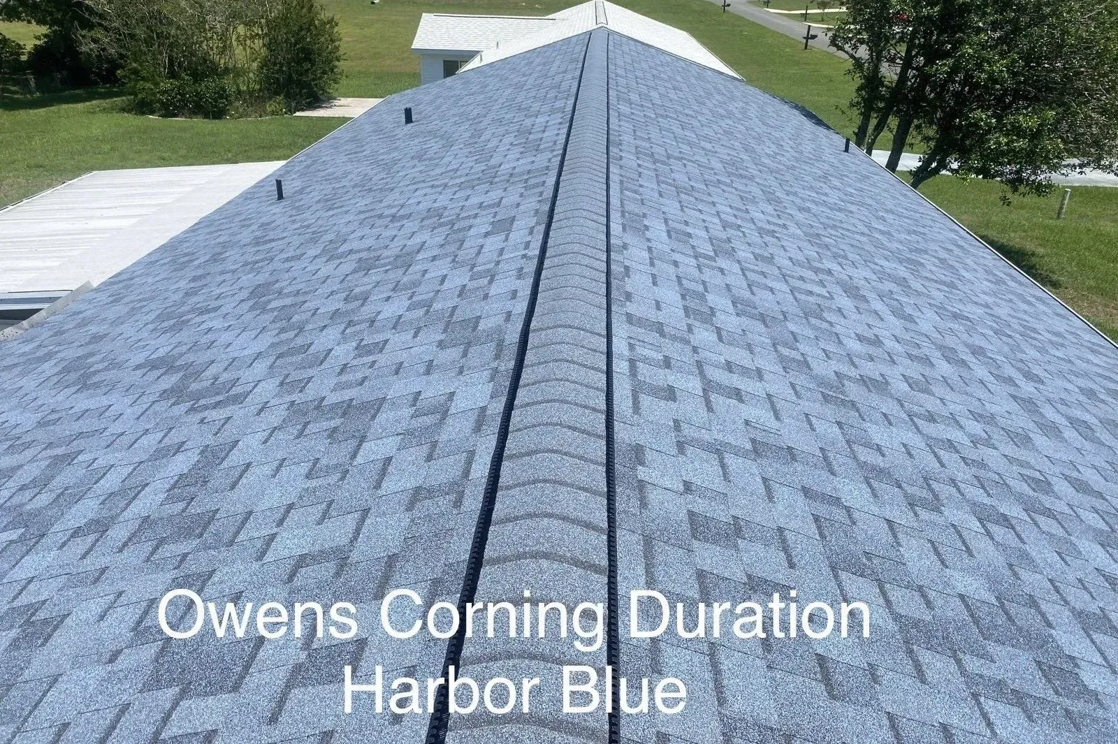 Blue-gray shingled roof with text reading “Owens Corning Duration Harbor-Blue”