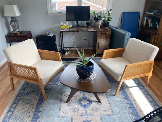 Reception area with gray walls, wooden floor, rug, and desk. A chair sits on the left.