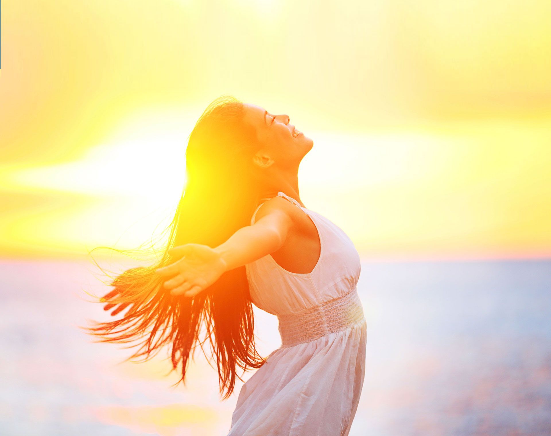Sunlight streams through fluffy white clouds in a blue sky.