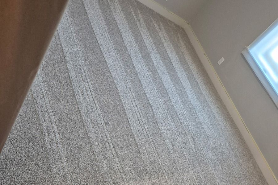 Carpeted hallway with light striped walls and a window on the right, viewed at an angle.