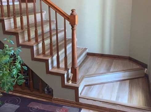 Wooden staircase with a turned banister and a small landing in a home interior.