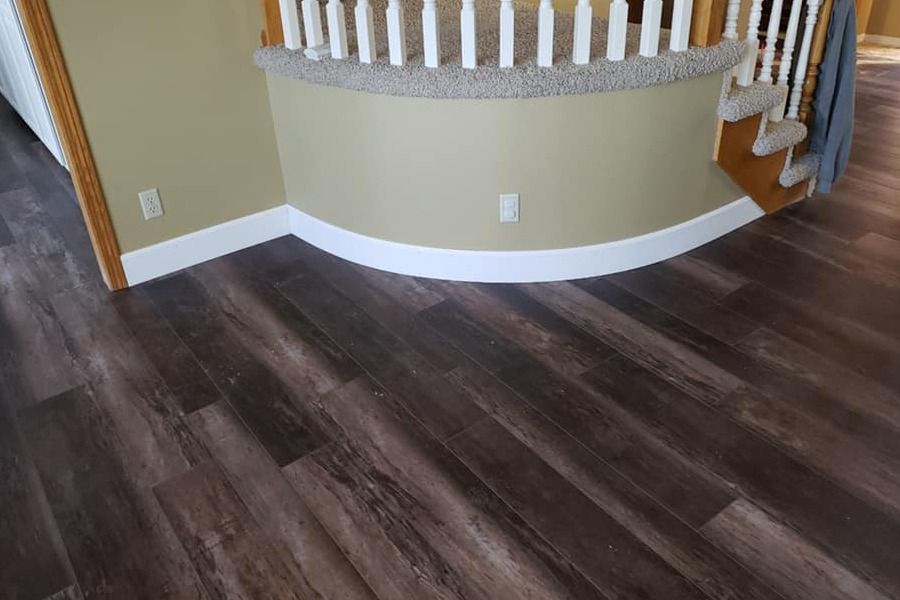Curved staircase landing with dark wood flooring and beige walls in a home interior