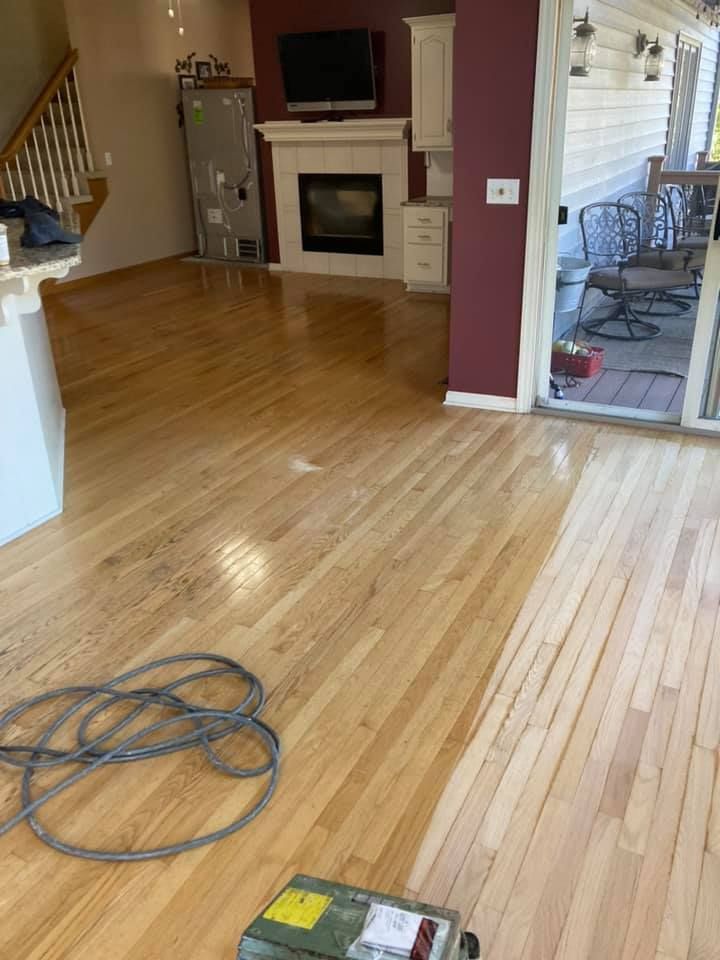 Partially finished living room with hardwood floor, fireplace, stairs, and construction tools on the floor