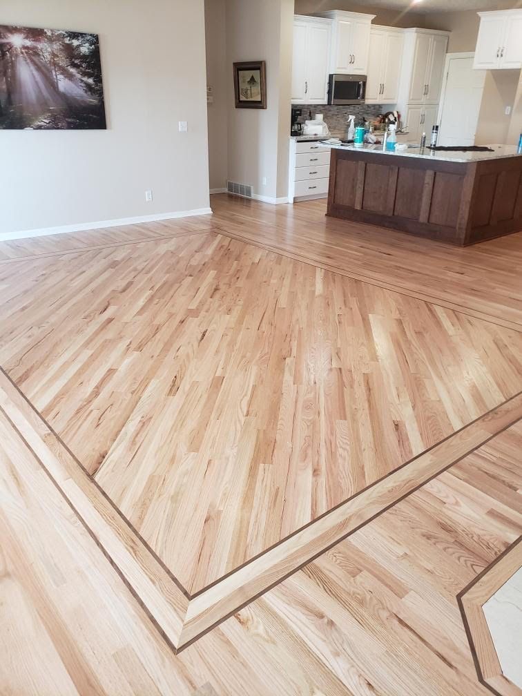 Open-concept kitchen and living area with light wood floors and dark wood island.