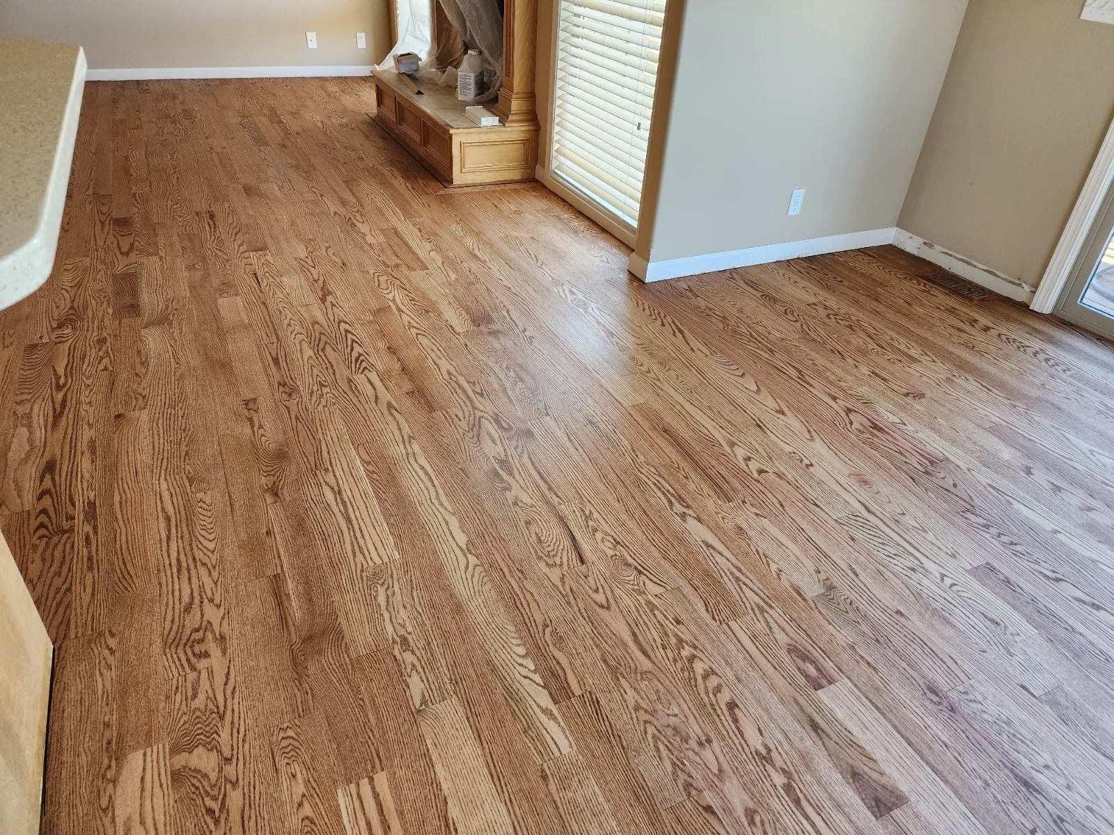 Empty living room with wood-look flooring and a fireplace in the corner