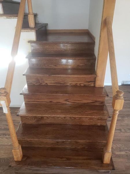 Wooden staircase with dark stained steps and light wood railings indoors