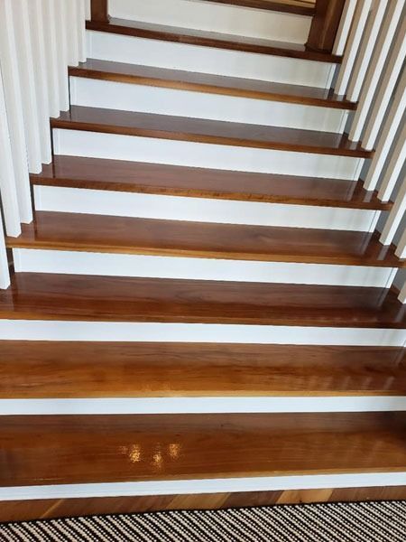 Wooden staircase with white side railings, viewed from bottom looking up