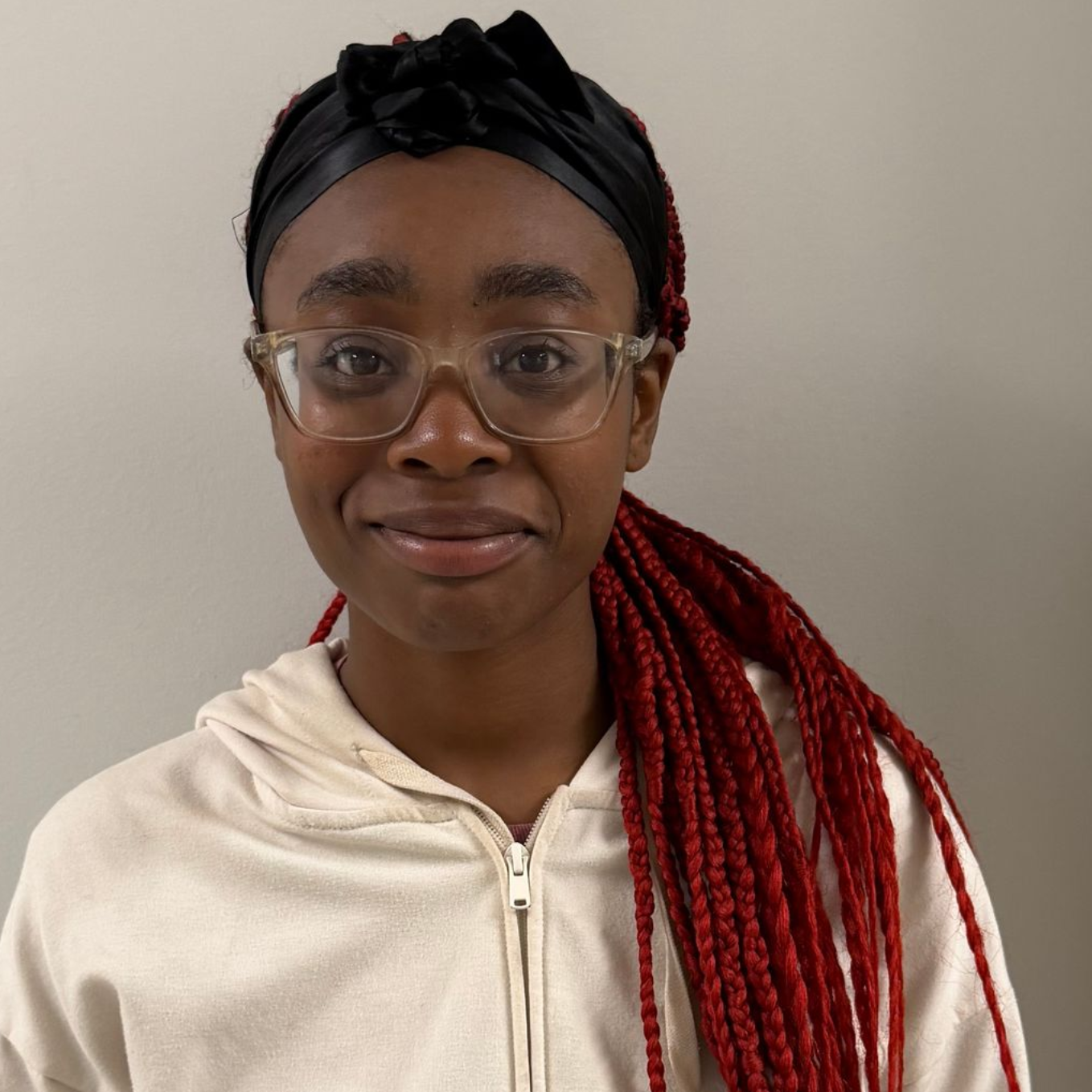 Woman wearing glasses and a yellow shirt, smiling against a white background.