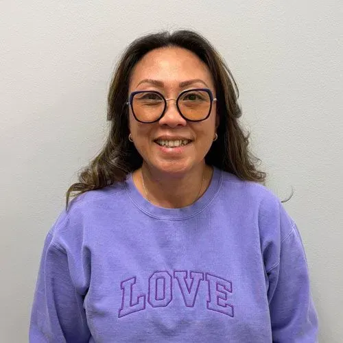 Woman wearing glasses and a purple 