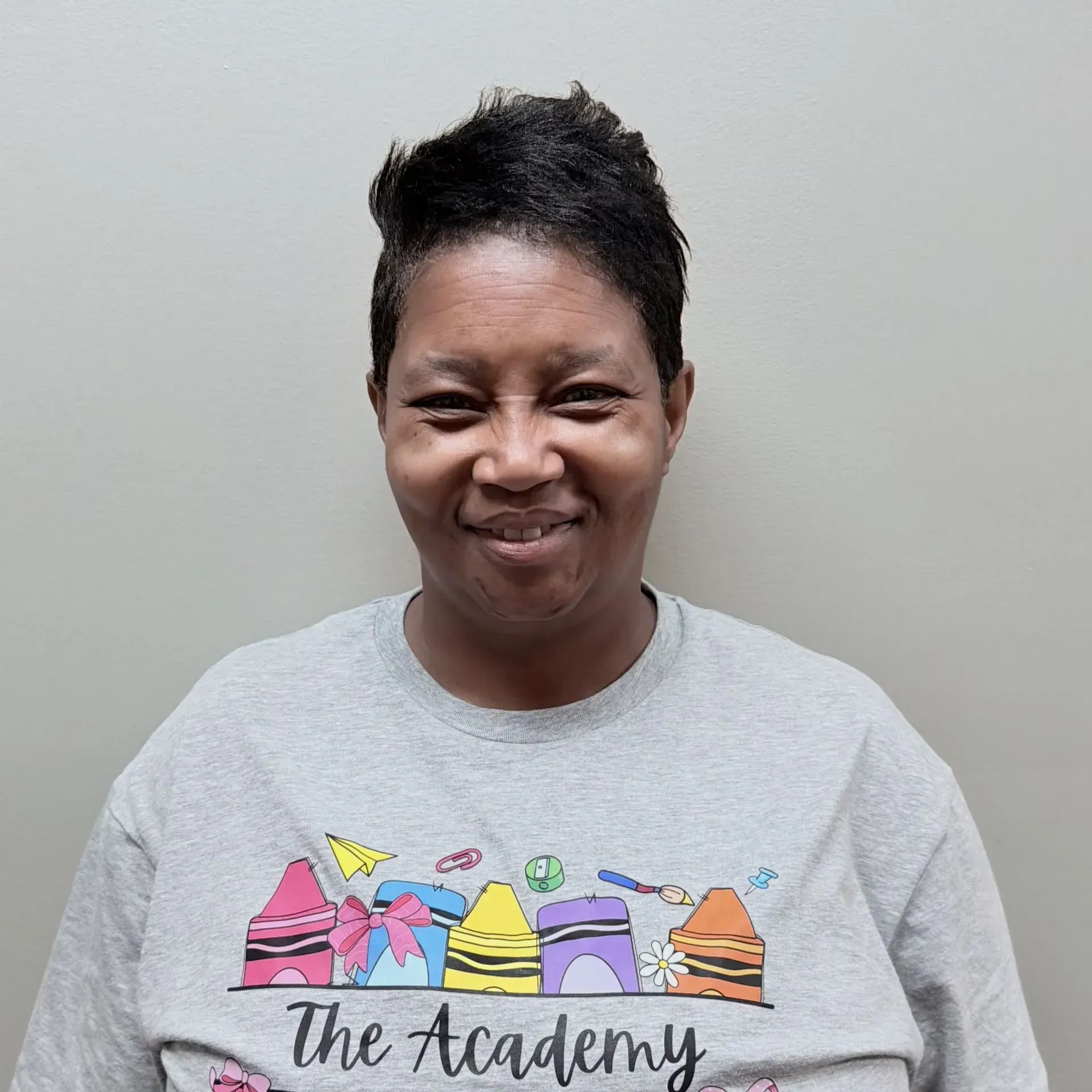 Woman wearing a gray t-shirt with crayon designs and 
