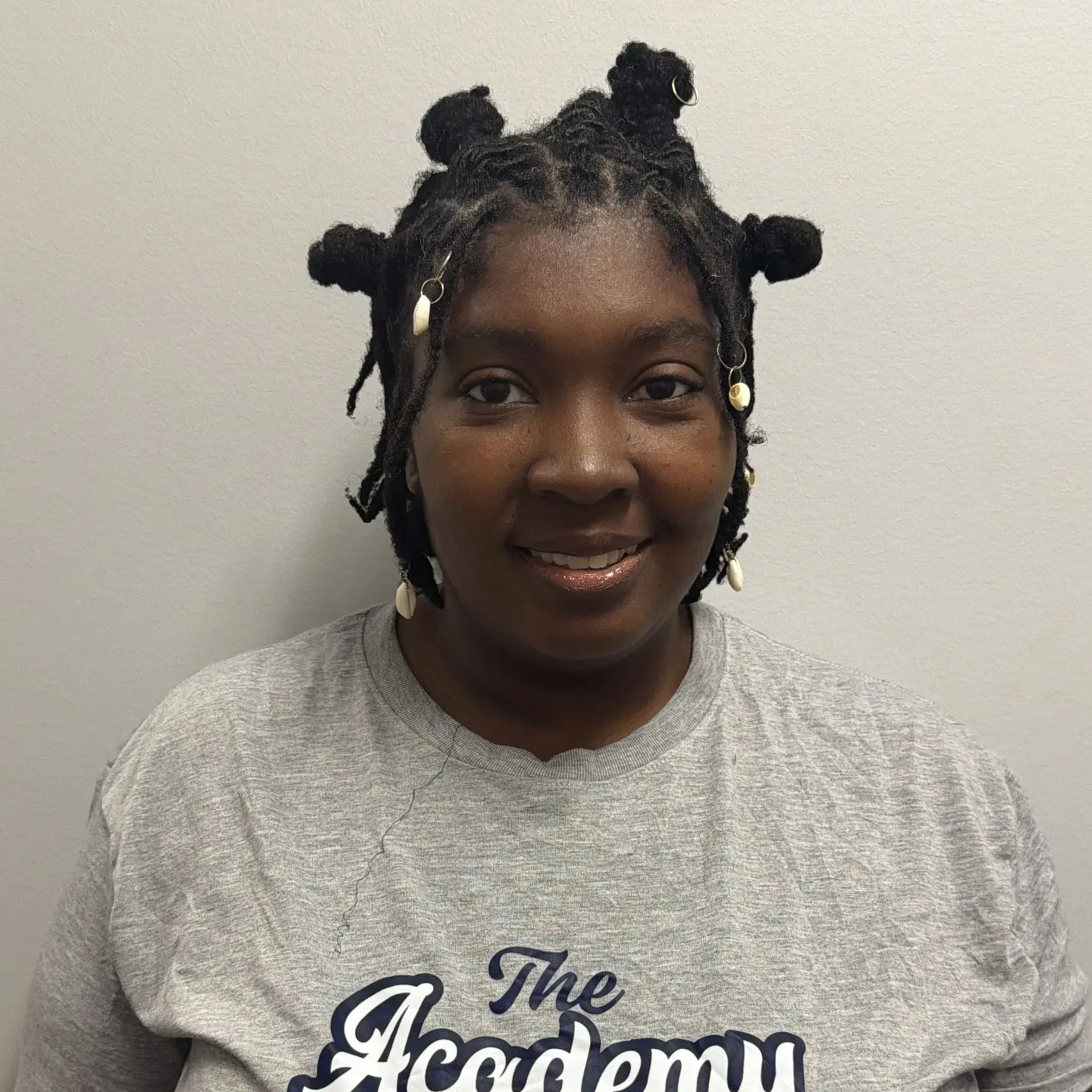 Person smiling, wearing a gray t-shirt with 