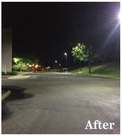 A picture of a parking lot at night with lights on.