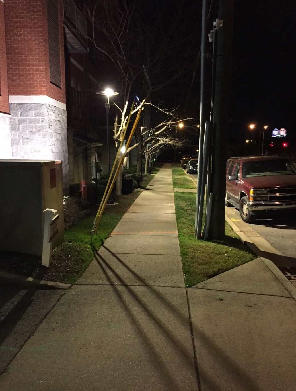 A red van is parked on the side of the road at night.