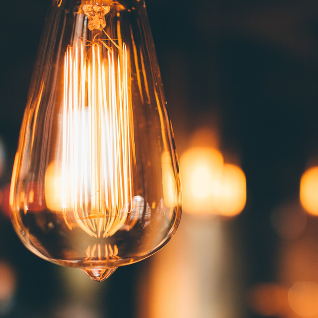 A close up of a light bulb hanging from the ceiling.