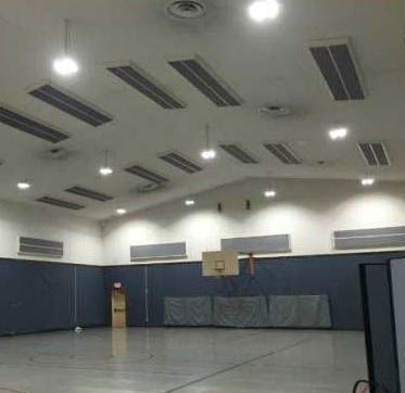 There is a basketball hoop in the middle of the gym.