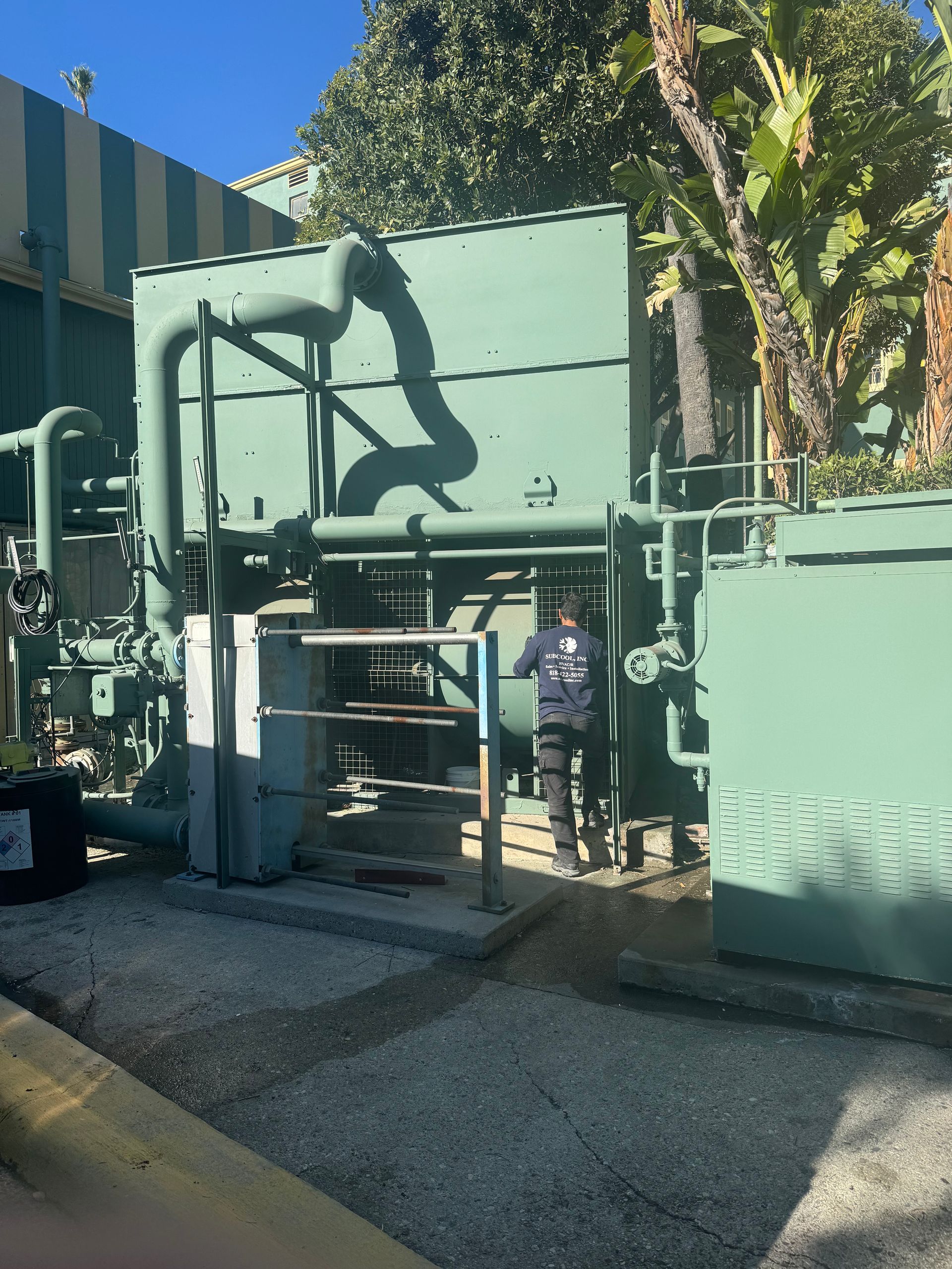 A man is standing in front of a large cooling tower
