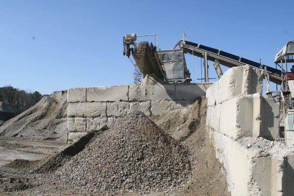 A pile of dirt is sitting in front of a conveyor belt.