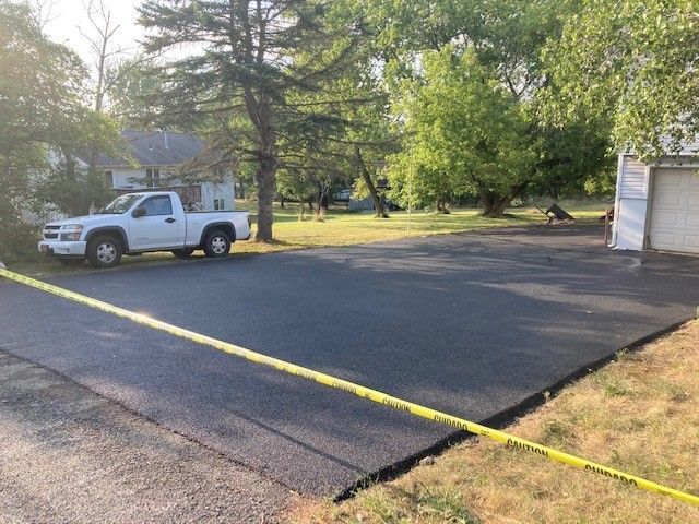 newly paved driveway with white pick-up truck in the background