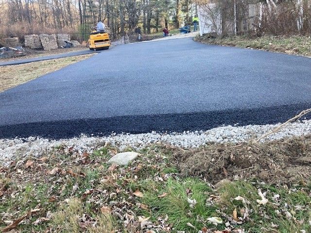 newly paved driveway with the paving tractor in the background